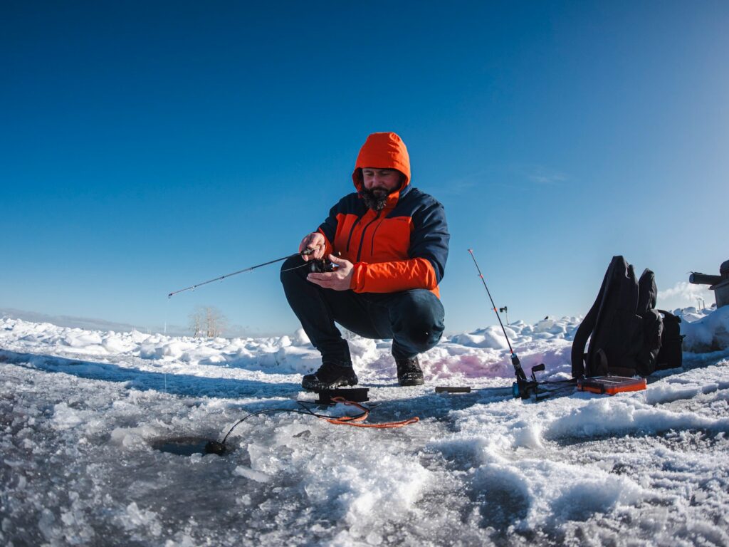 Man ice fishing on a frozen lake.